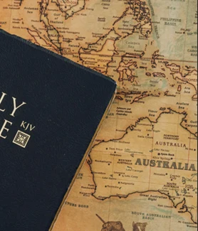 A King James Bible resting on a world map